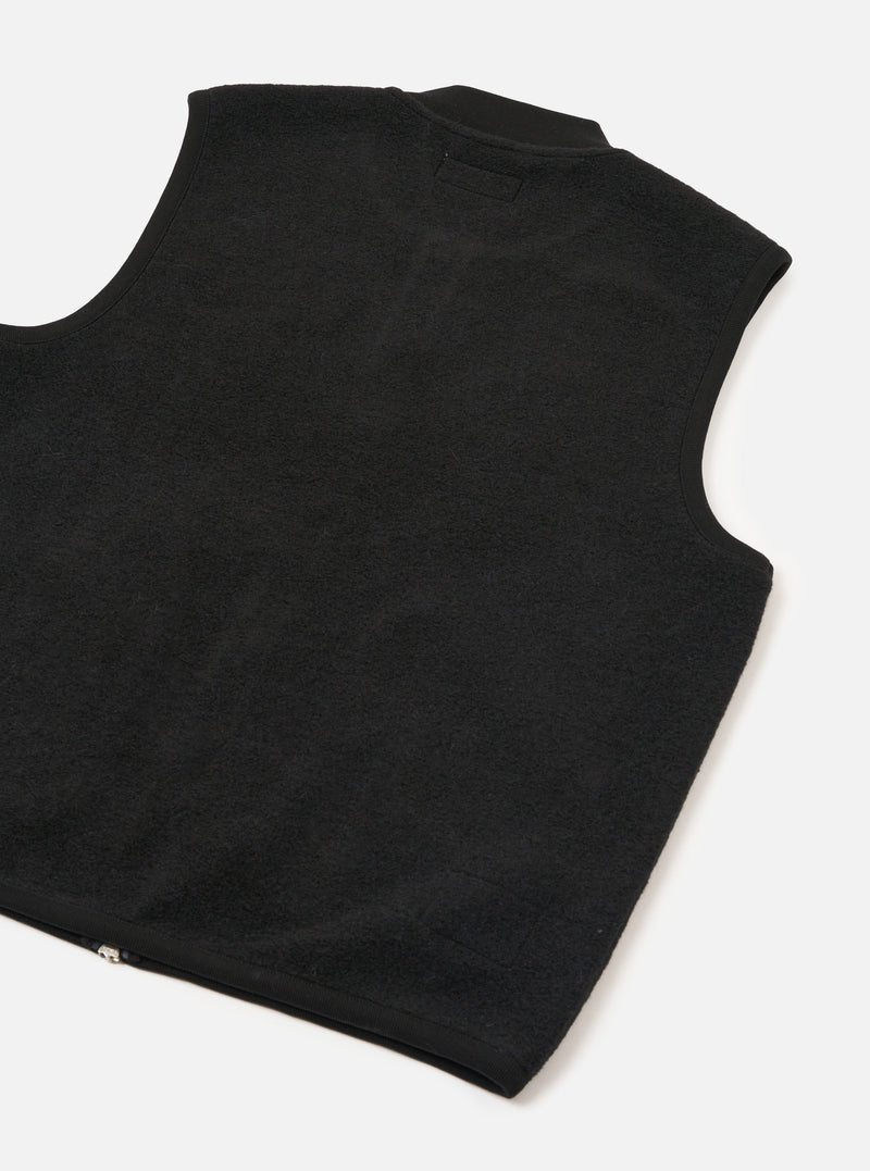Front view of the Universal Works Black Wool Fleece Zip Waistcoat displayed on a plain white background. The fleece texture, two-way front zipper, ribbed neckline, and two angled lower patch pockets are prominently featured.