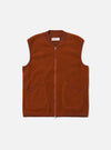 The Rust Wool Fleece Zip Waistcoat, a rust-colored vest with a full zipper and pockets, is laid flat on a white background. The waistcoat has a ribbed collar and arm openings.