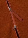 Close-up of the rust-colored wool fleece zip waistcoat, showing the texture of the fleece and the zipper detail. The Rust Wool Fleece Zip Waistcoat is stylish and warm.
