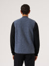Back view of a model wearing a Slate Blue Wool Fleece Zip Waistcoat over a black long-sleeve shirt, against a white backdrop. The waistcoat is a textured wool fleece.