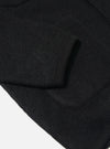 Close-up of the black wool fleece cardigan on a white background, showing the sleeve and pocket detail.