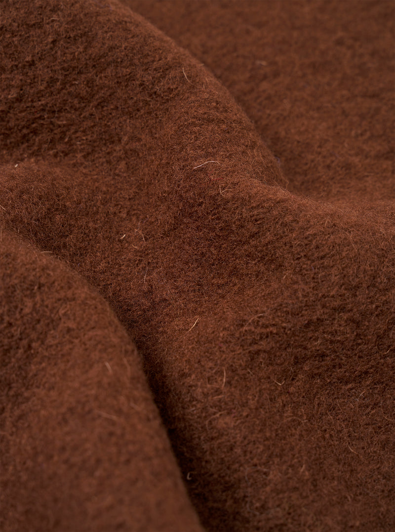 Close-up of the cacao wool fleece fabric used in the cardigan, showing a dense, brushed texture with visible individual fibres throughout. The rich chocolate brown tone is even across the surface, with soft folds highlighting the fabric's volume and warmth.