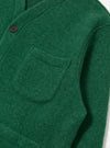 Close-up of a green wool fleece cardigan with a pocket, showcasing the material and texture. The Green Wool Fleece Cardigan is on a white surface.