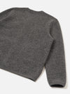 Close-up flat lay of a grey marl wool fleece cardigan on a white studio surface, shot from behind and above. The boiled wool texture is clearly visible across the back panel and one full sleeve. A ribbed hem and ribbed cuff are shown at the bottom of the frame.