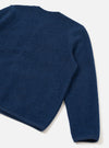 Close-up flat lay of an indigo wool fleece cardigan on a white studio surface, showing the back panel and one sleeve. The boiled wool texture is clearly visible across the body. A ribbed hem and ribbed cuff are visible at the bottom edges.