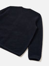 Navy wool fleece cardigan laid flat on a white surface, shot at an angle showing the back and one sleeve. The textured fleece has a dense, nubby surface. A ribbed cuff is visible at the sleeve end, with a clean bound hem at the base.