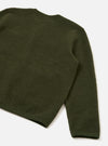 Close-up rear detail of an olive wool fleece cardigan, flat lay on a white studio surface. The shot shows the back panel and one full sleeve, highlighting the dense, textured fleece fabric. A ribbed hem and ribbed cuff are visible at the edges.