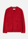 Scarlet wool fleece cardigan laid flat on a white studio backdrop. Collarless V-neckline with a Universal Works label visible at the neck. Five dark buttons down the centre front. Two chest patch pockets and two larger lower patch pockets in matching fleece. Plain cuffs and a straight hem. Textured boiled wool fleece fabric throughout.