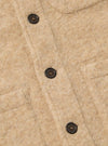Close-up of the Fawn Wool Fleece Field Jacket. The jacket is a light tan color and made of a soft, woolly material. It has dark brown buttons and a classic fit. The background is a plain white surface.