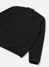 Black wool fleece zip bomber shot as a flat lay on a white surface, angled to show the back and one sleeve. The textured fleece is visible across the body and sleeve. A ribbed cuff is visible at the hem of the sleeve. A small silver zip pull is visible at the lower left hem.