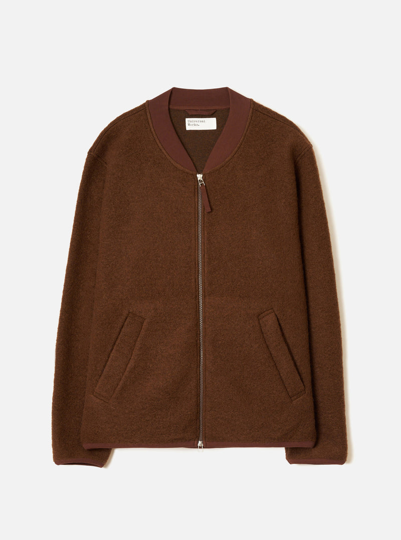 Cacao brown wool fleece zip bomber laid flat on a light grey seamless backdrop. Ribbed bomber collar in a darker burgundy-brown knit trim. Full-length silver zip with a small zip pull. Two open welt hand pockets at the hem. Ribbed cuffs in matching trim. Universal Works woven label visible at the neck.