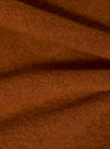 Close-up of the Rust Wool Fleece Zip Bomber fabric. The rust-colored wool fleece is soft and textured, draped to show its cozy feel.