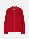Scarlet wool fleece zip bomber laid flat on a white studio backdrop. Boiled wool texture throughout, ribbed bomber collar in tonal satin fabric, centre-front zip with silver teeth and a red leather pull tab. Two welt pockets at the hip, ribbed cuffs and hem. Universal Works woven label visible at the neck.