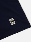 Close-up of the Navy Single Jersey Core Tee showing the fabric and label detail on a white background.