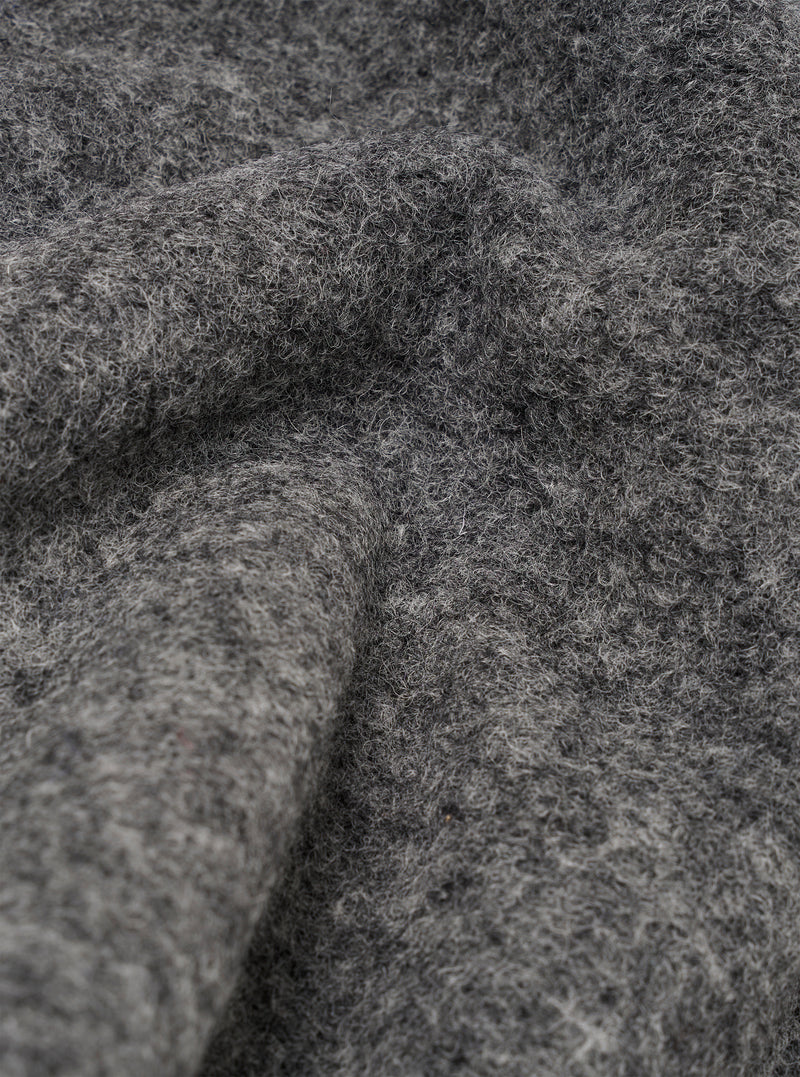 Close-up detail shot of the grey marl wool fleece fabric used in the zip liner jacket. The texture is thick, fluffy and heavily brushed with visible loose fibres throughout. The fabric is folded and draped, showing depth and volume in the pile against a neutral background.