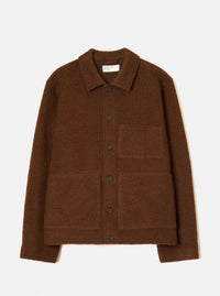 Cacao brown wool fleece uniform jacket laid flat on a light grey studio backdrop. Features a spread collar with a Universal Works woven label, a single-breasted button placket with six dark buttons, one chest patch pocket, two large lower patch pockets, and ribbed cuffs and hem.
