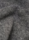 Close-up of the grey marl wool fleece fabric on the Uniform Jacket, showing the dense, brushed texture with fine fibres and a soft, chunky pile. Folds and curves in the material highlight the fabric's depth and volume. No background visible.