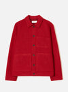 Scarlet wool fleece chore jacket laid flat on a plain white studio backdrop. Features a point collar, six dark horn buttons down the centre front, one chest patch pocket and two large lower patch pockets. Boiled wool fleece texture throughout. Universal Works woven label visible at the neck.
