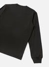 Back detail of a black long-sleeve pocket tee in smooth single jersey cotton. The shot shows the upper back, right shoulder, and full sleeve, cropped at the hem. A ribbed cuff is visible at the wrist. Plain light grey studio backdrop. No model or mannequin present.