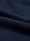Close-up of navy brushback fleece fabric, showing a soft, dense knit texture with a smooth face and subtle pile. The material is folded to reveal its weight and structure. No garment details or background are visible.