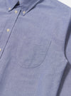 Close-up of the Blue Oxford Daybrook Shirt. The light blue cotton shirt features a button-down collar and chest pocket. Shot against a plain white backdrop.
