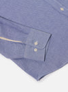 Close-up of the Blue Oxford Daybrook Shirt on a white background. The shirt is made of a textured blue fabric and has white buttons.
