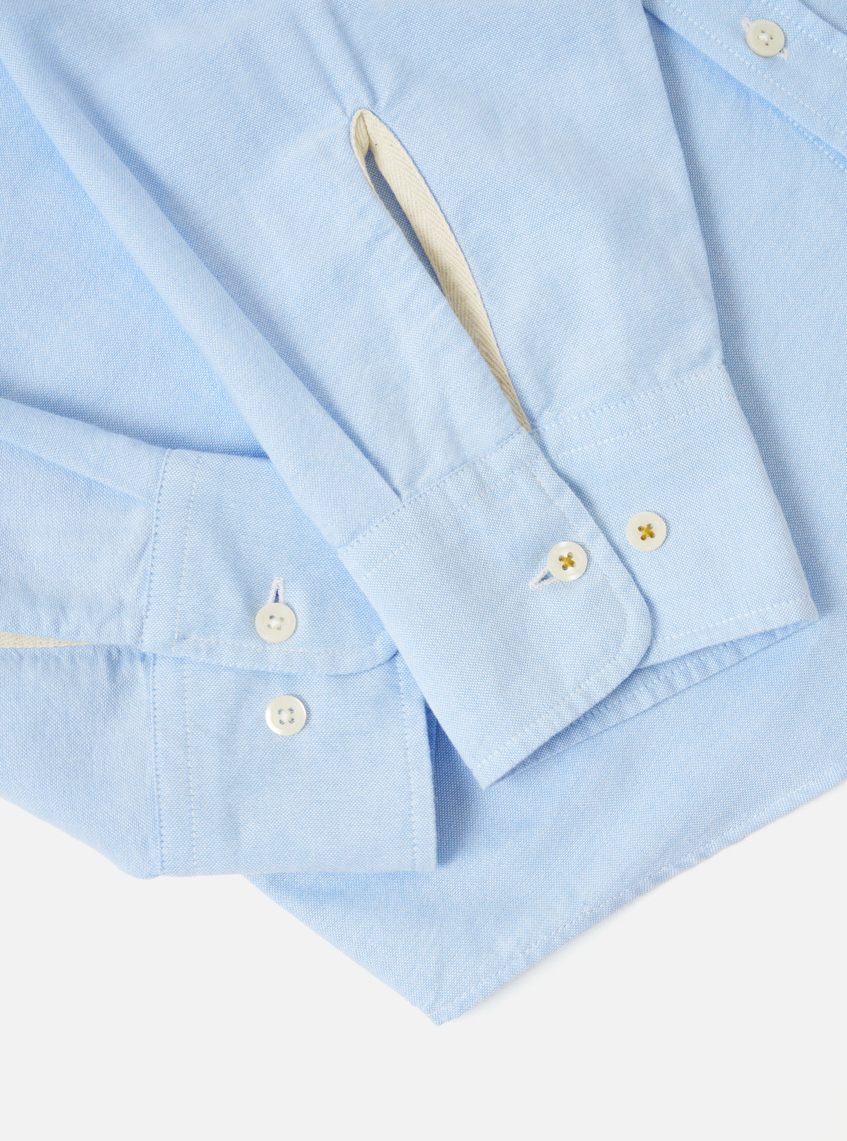 Close-up of the Sky Blue Oxford Daybrook Shirt on a white background. Shows the cuff and sleeve details, highlighting the light blue oxford fabric and button details.
