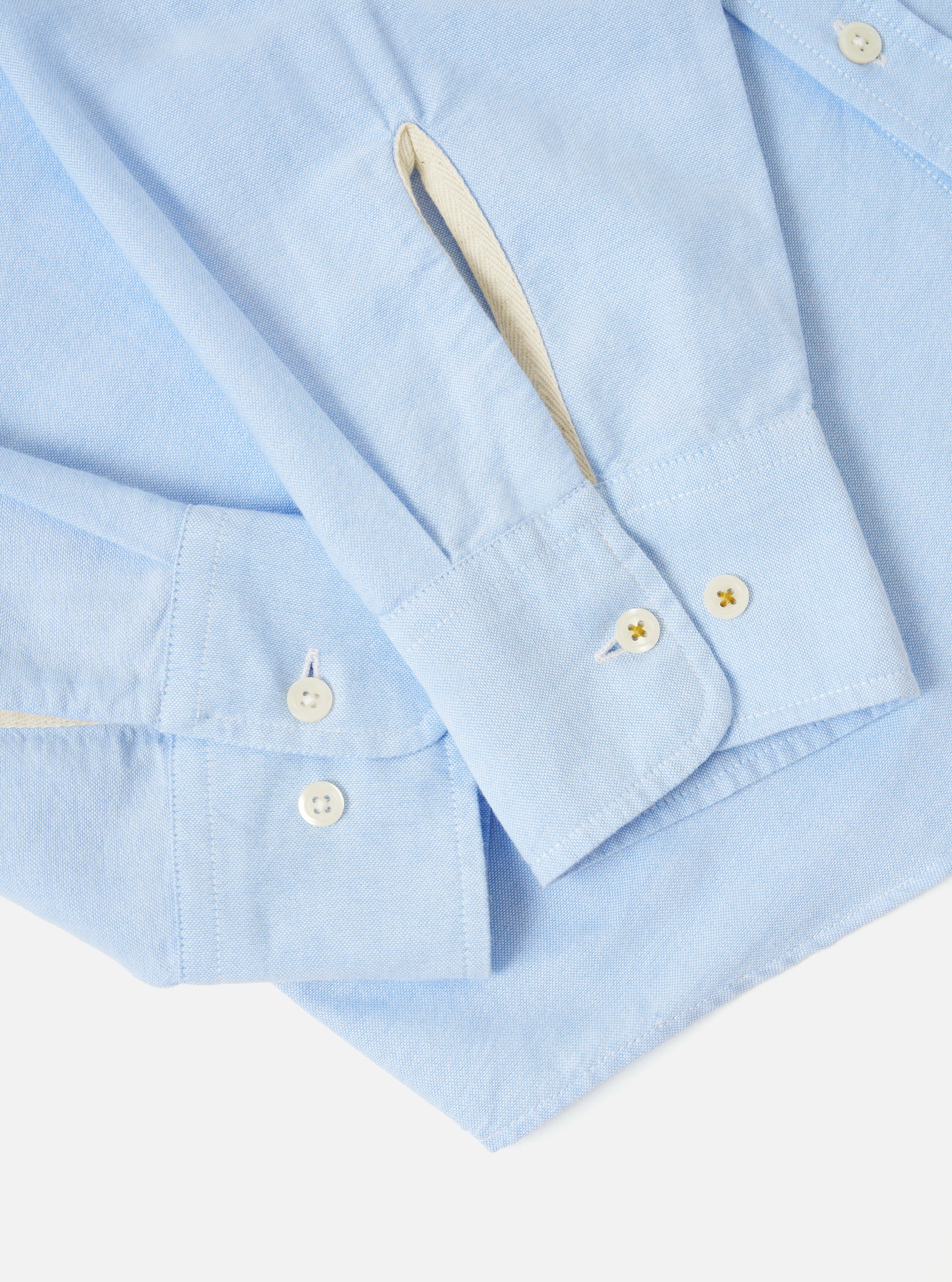 Close-up of the Sky Blue Oxford Daybrook Shirt on a white background. Shows the cuff and sleeve details, highlighting the light blue oxford fabric and button details.