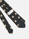Close-up of a Black Bold Dot Print Rayon Tie on a white surface. The tie features large tan polka dots. A "Universal Works." tag is visible.