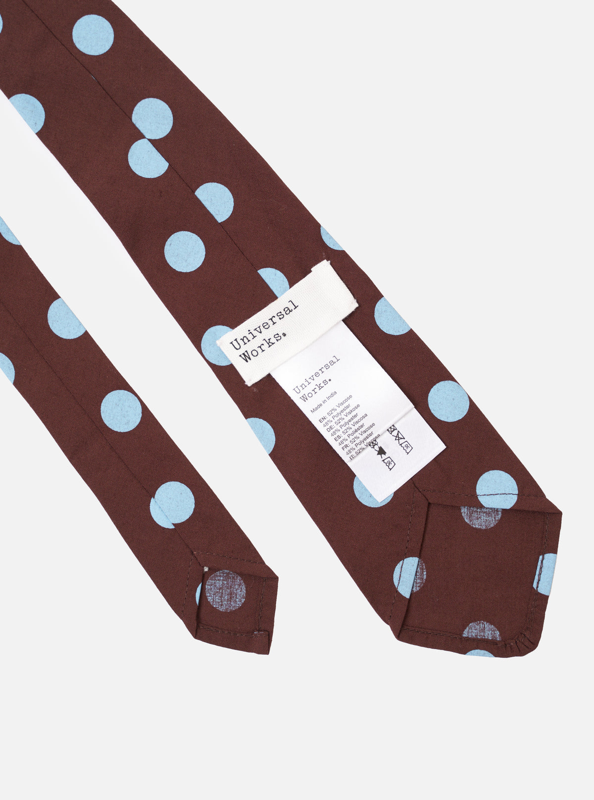 The Brown Bold Dot Print Rayon Tie is shown in a detail view as a flat lay against a plain white background. The tie features a rich brown base with a repeating pattern of large, bold dots. The image highlights the smooth, fluid texture of the rayon fabric and the clean construction of the garment.