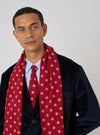 A model wears a Red Bold Dot Print Rayon Evening Scarf with a navy jacket. The scarf is draped around his neck. The background is a plain white.