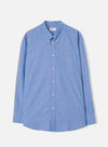 Blue Prince Chambray Daybrook Shirt laid flat on a light grey studio backdrop. The long-sleeve shirt features a point collar, full-length button placket, chest patch pocket, and buttoned cuffs.