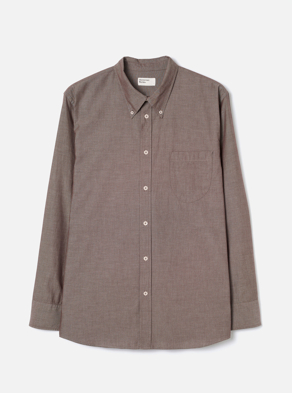 Front view of the Brown Prince Chambray Daybrook Shirt laid flat on a light grey studio backdrop. Features a spread collar, button-up front closure, single chest patch pocket, and long sleeves with buttoned cuffs. No model or mannequin present.