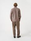 Back view of a male model wearing the Brown Prince Chambray Daybrook Shirt against a plain light grey backdrop. The long-sleeve cotton shirt has a classic button-down fit with a smooth back yoke.