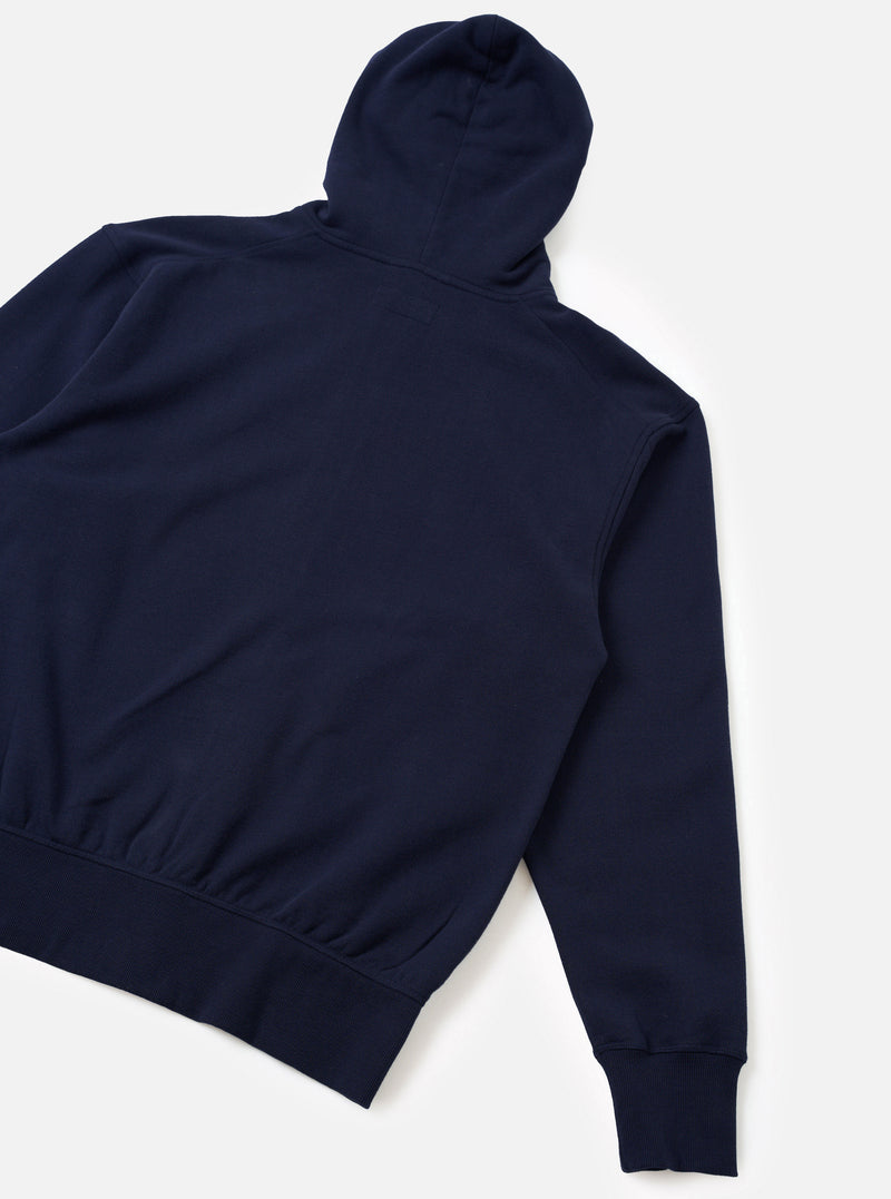 The Navy Brush Back Sweat Core Hoody is laid flat on a white backdrop showing the rear view. Features smooth dense navy fleece fabric, an upright hood at the top, ribbed cuffs, and a ribbed hem running along the bottom edge.