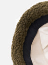 Close-up of the cableami® Olive Toque Boa Cap on a white background. The hat features an olive green, textured outer layer, a black band, and a cream-colored inner lining.