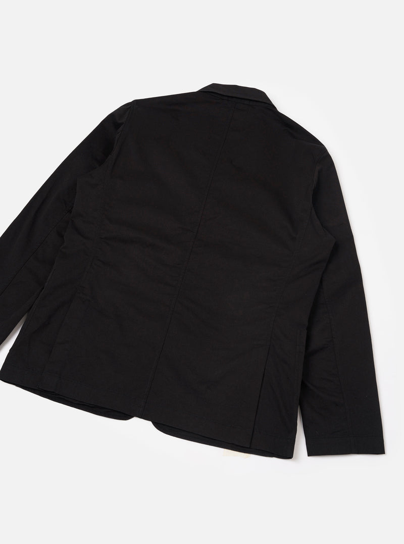 Rear view of the Black Twill London Jacket displayed flat on a clean white backdrop. The photo highlights the smooth black cotton twill fabric, neat back seams, structured shoulders, and clean bottom hemline of the garment.