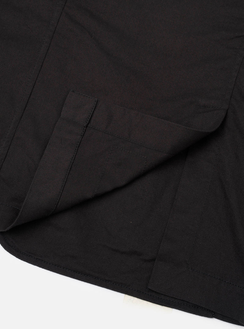 Detail view of the Black Twill London Jacket on a plain off-white background, highlighting the durable cotton twill weave, subtle stitch lines, lapel collar, and tailored structure.