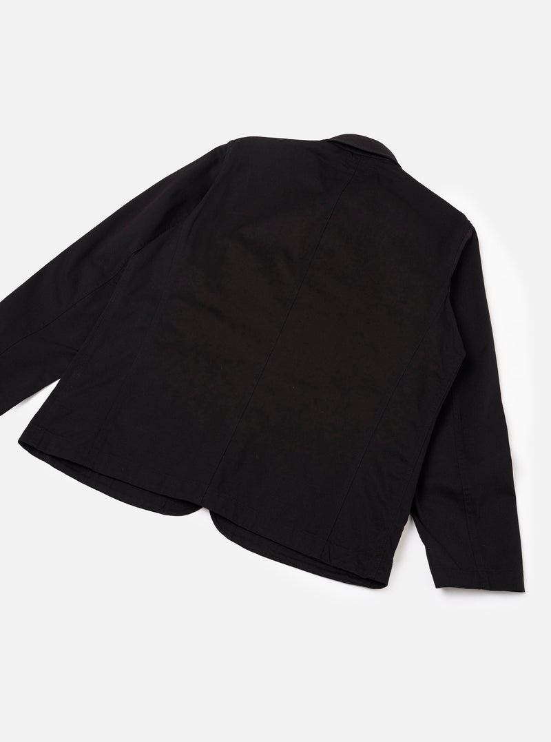 Back view of the Black Twill Bakers Chore Jacket against a plain off-white background, illustrating the clean black twill back panel, straight hem line, set-in sleeves, and classic chore jacket design.