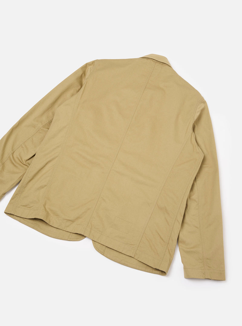 Back view of the Sand Twill Bakers Chore Jacket presented against a plain white background. Shows the clean beige sand twill construction, neat shoulder yoke seams, and straight bottom hem finish.