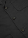 Close-up of a Black Twill Three Button Jacket showing the fabric texture, button details, and pocket stitching. The jacket is laid flat on a neutral surface.