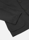 Close-up of a Black Twill Three Button Jacket on a white surface. The twill fabric is visible, along with the sleeve and buttons.