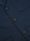 Close-up of the Navy Twill Three Button Jacket showing the twill fabric texture, brown buttons, and pocket detail. The jacket is laid flat on a neutral surface.