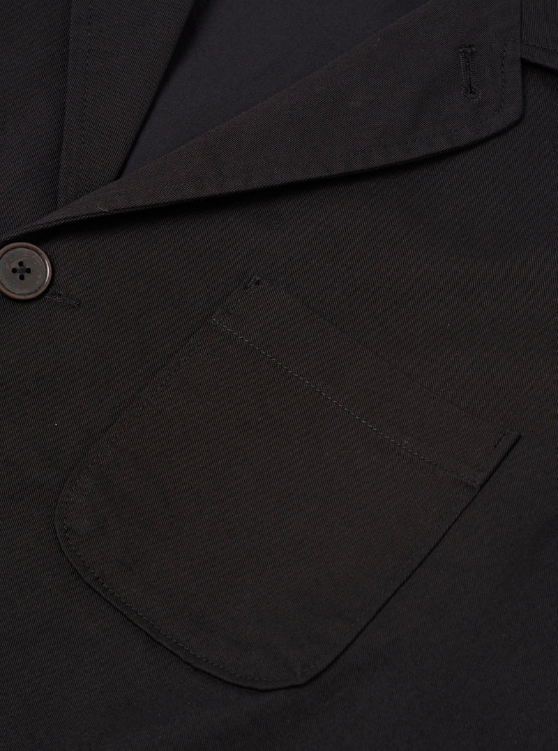 Detailed close-up view of the Black Twill Three Button Jacket set against a clean white background, emphasizing the fine twill fabric weave, lapel stitching, and dark horn button fastenings.