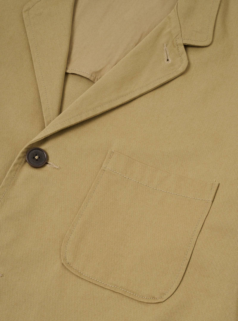 Front view of the Sand Twill Three Button Jacket displayed against a plain off-white background. Features three front buttons, notch lapels, structured chest, and front patch pockets.