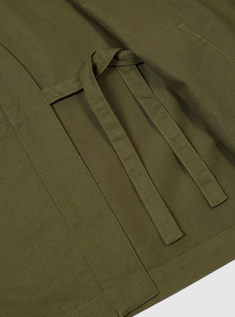 Close-up detail shot of the Light Olive Twill Kyoto Work Jacket set on a neutral background. Focuses on the wrap tie closure system, durable twill texture, and reinforced stitching along the seam.