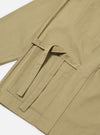 Close-up of the sand twill Kyoto Work Jacket on a white surface. The jacket features a tie closure and visible stitching.