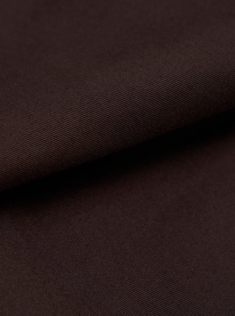 A detailed, close-up fabric swatch of the Brown Twill Military Chino is shown, highlighting the distinct diagonal 3/1 weave of the brown cotton material. The image focuses entirely on the texture and color of the fabric against a neutral background.