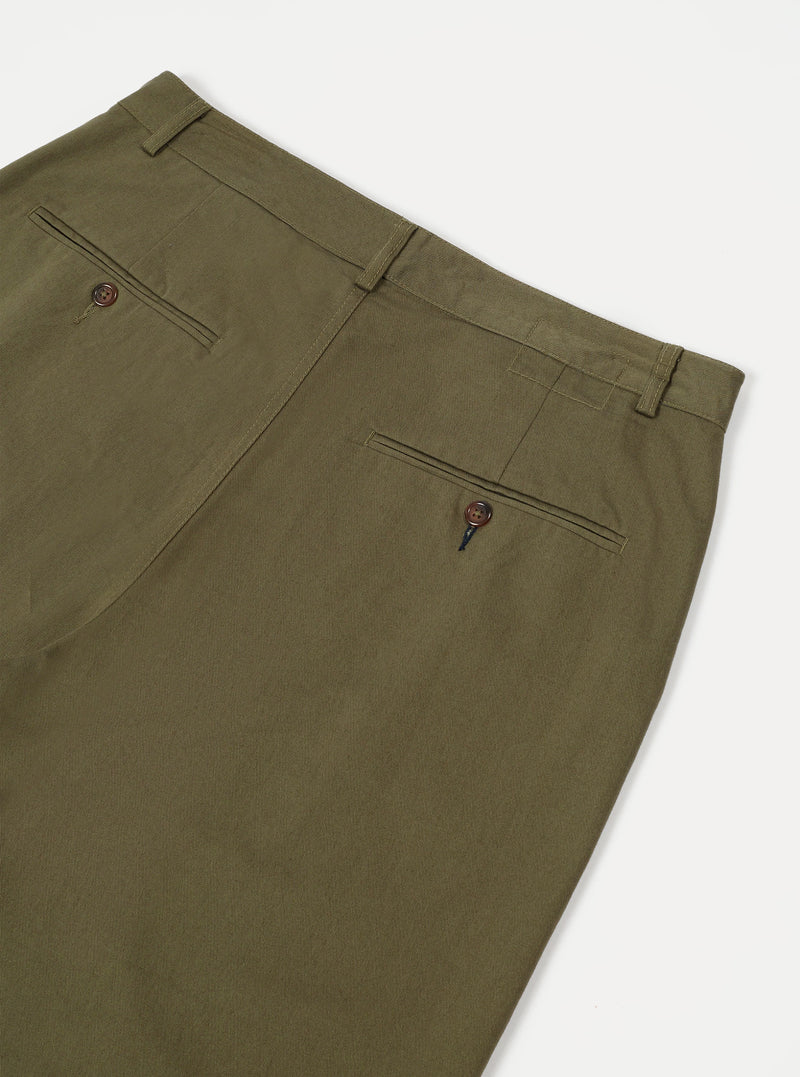 A close-up shot of the Light Olive Twill Military Chino trousers set against a neutral backdrop. Focuses on the olive cotton twill texture, waistband stitching, and front button closure details.