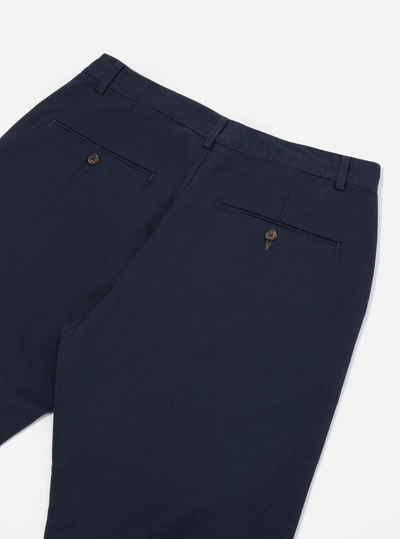 Detailed close-up view of the Navy Twill Military Chino against a neutral white background. Shows the fine 3/1 cotton twill weave texture, tonal waist button closure, precise stitching along the waistband, and clean pocket opening.